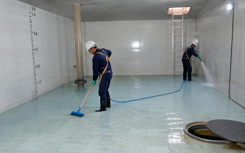 Equipe limpando um grande reservatório de condomínio